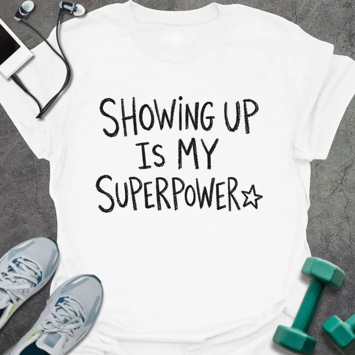 White t-shirt printed with "SHOWING UP IS MY SUPERPOWER" in black handwritten lettering, with a star outline