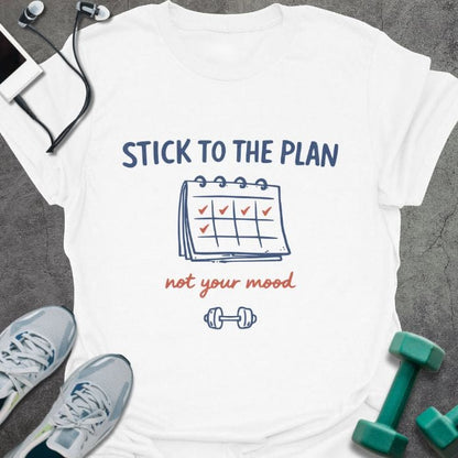 White t-shirt printed with "STICK TO THE PLAN not your mood" in red and blue, with calendar and checkmarks illustration