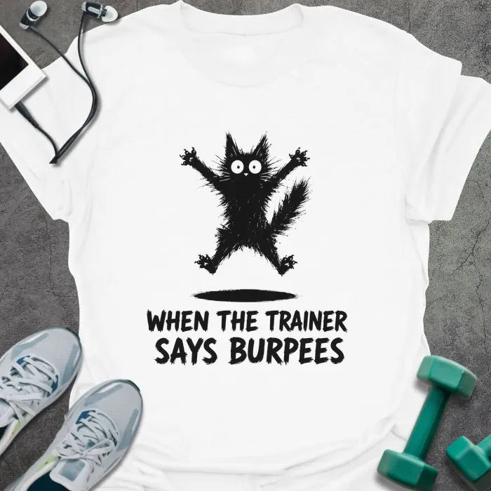 White t-shirt printed with "WHEN THE TRAINER SAYS BURPEES" in black italic lettering, with a black freaked-out cat with wide eyes