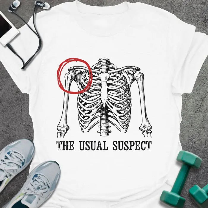 White t-shirt printed with "The Usual Suspect" in white and red, with a skeleton anatomy illustration highlighting the heart in red