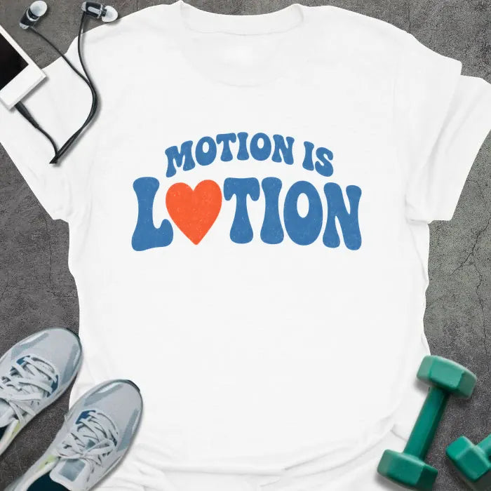 White t-shirt printed with "MOTION IS LOTION" in blue and orange, with heart icon