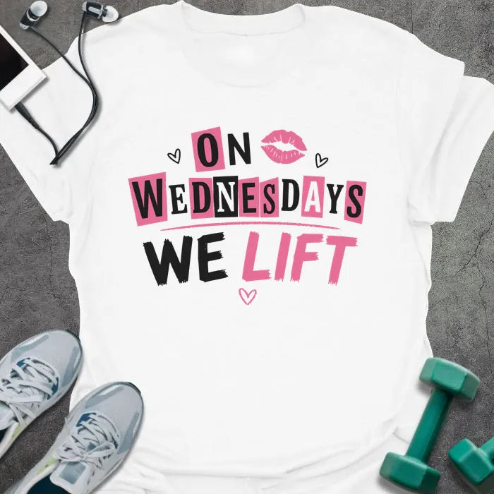 White t-shirt printed with "On Wednesdays We Lift" in pink and black, with an illustration of lips and hearts