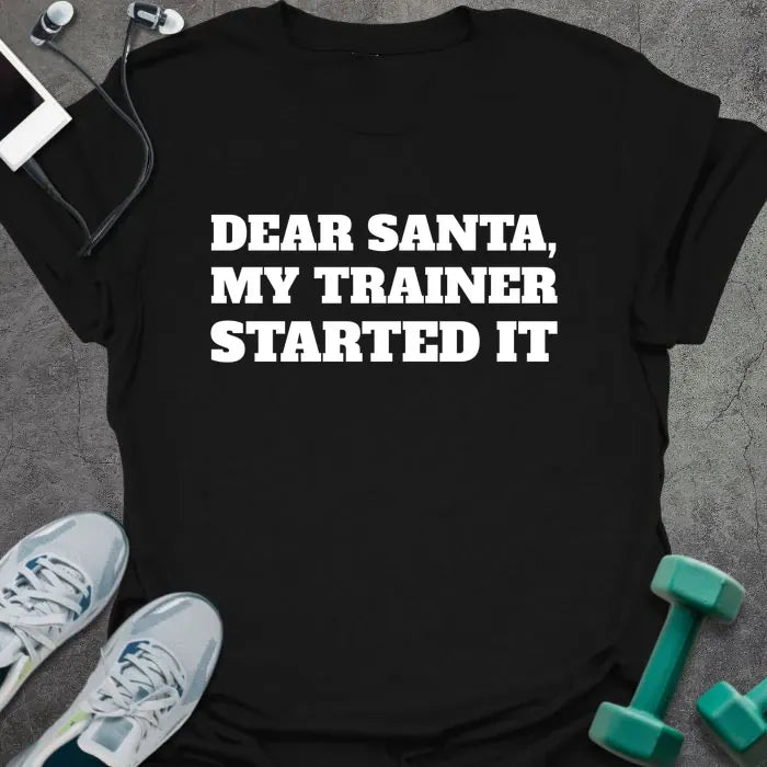 Black t-shirt printed with "DEAR SANTA, MY TRAINER STARTED IT" in white