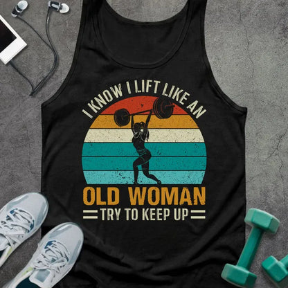 Black tank top printed with "I Know I Lift Like an Old Woman Try to Keep Up" in white, orange, and teal, with silhouette and sunset stripes