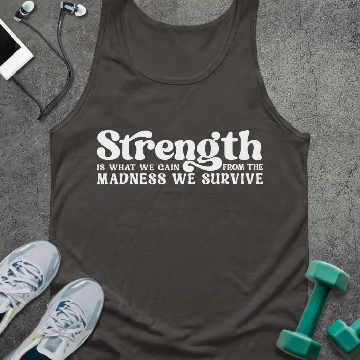Dark grey tank top printed with "Strength IS WHAT WE GAIN FROM THE MADNESS WE SURVIVE" in white