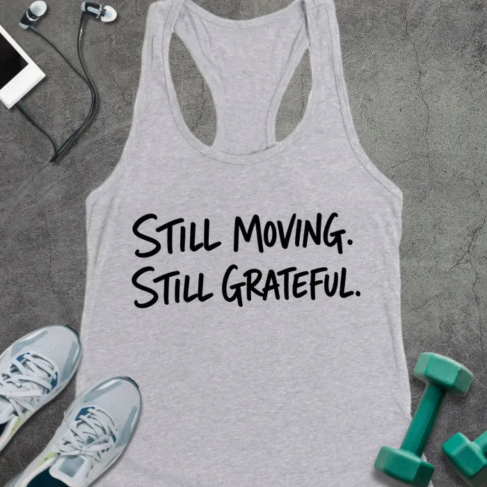 Heather Grey tank top printed with "STILL MOVING. STILL GRATEFUL." in black handwritten lettering