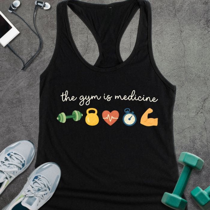 Black tank top printed with "the gym is medicine" in white and multicolor, with colorful gym icons including dumbbells, kettlebell, heartbeat, and flexed arm