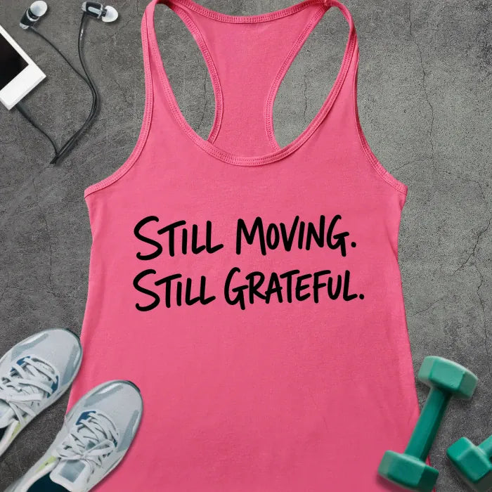 Hot Pink tank top printed with "STILL MOVING. STILL GRATEFUL." in black handwritten lettering