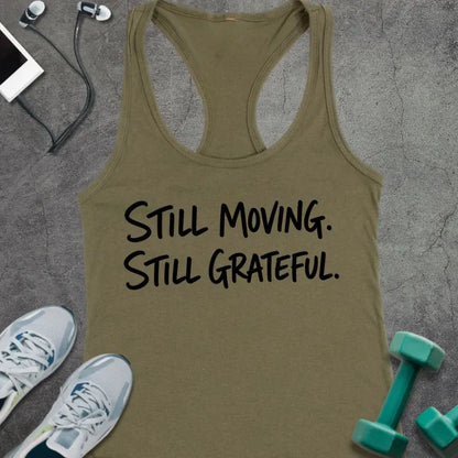 Military Green tank top printed with "STILL MOVING. STILL GRATEFUL." in black handwritten lettering