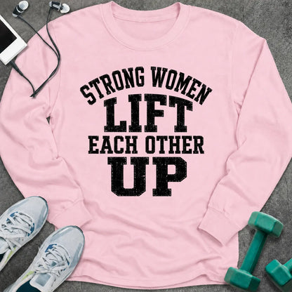 Light pink long sleeve tee printed with "Strong Women Lift Each Other Up" in black distressed varsity lettering